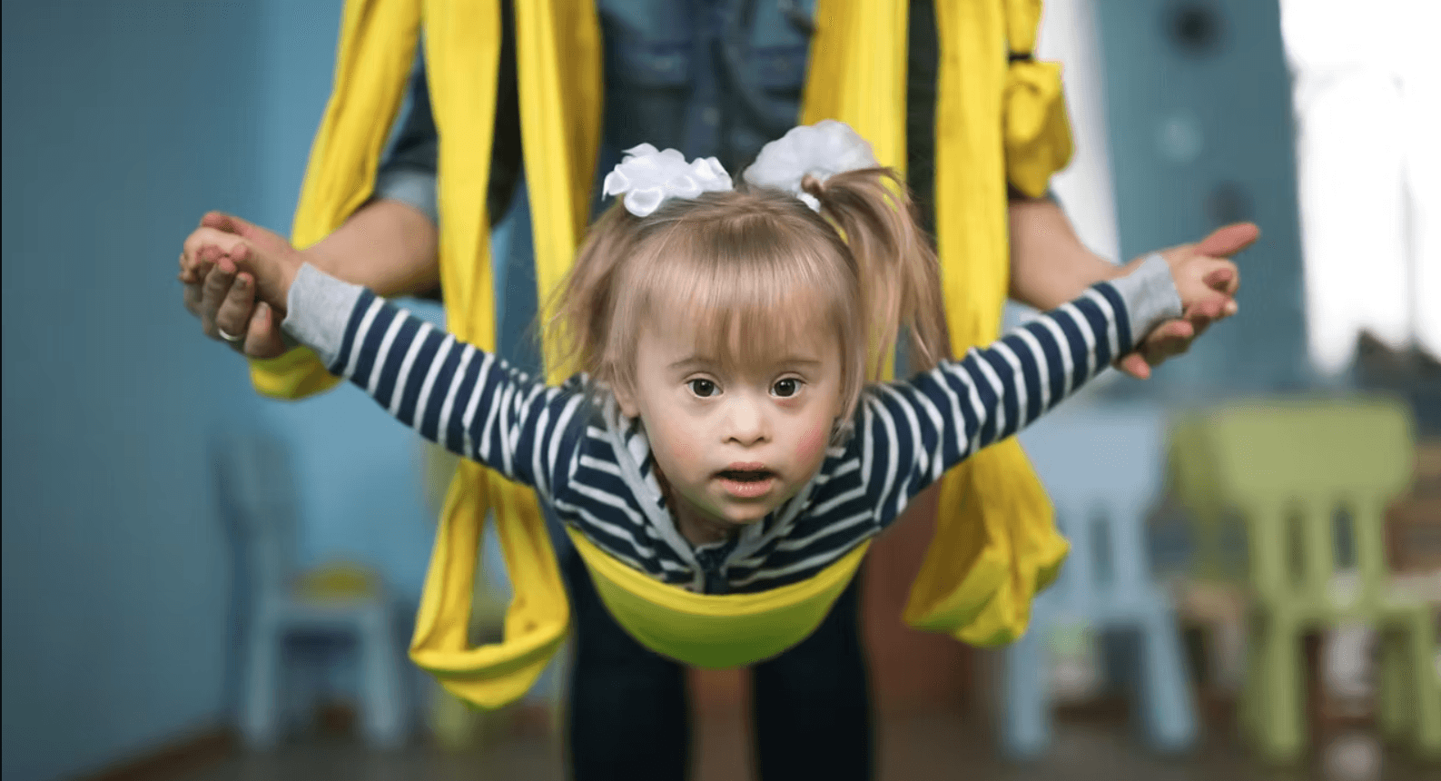 Moment de bucurie prin mișcare — copil susținut cu brațele întinse